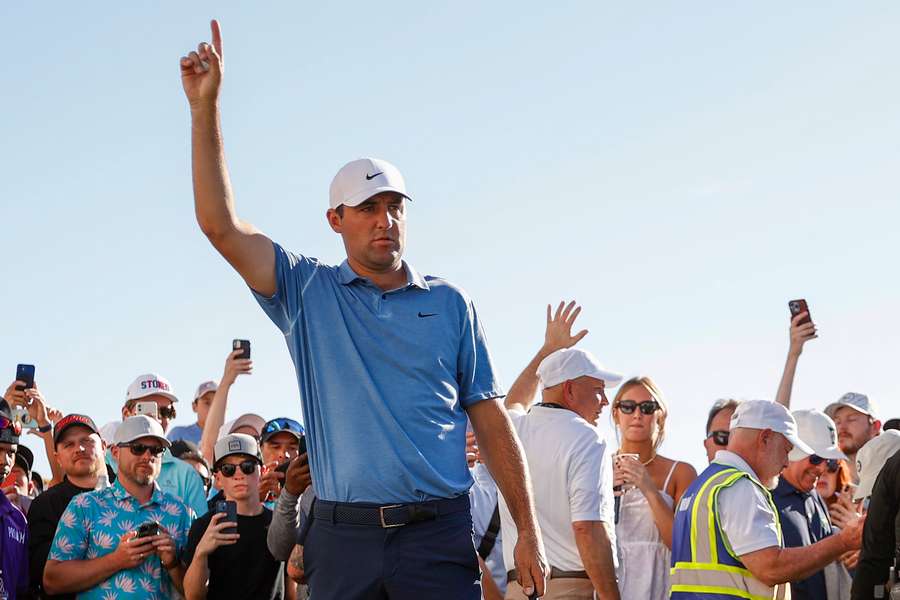 Scottie Scheffler reacts before playing his approach shot on the 18th green 