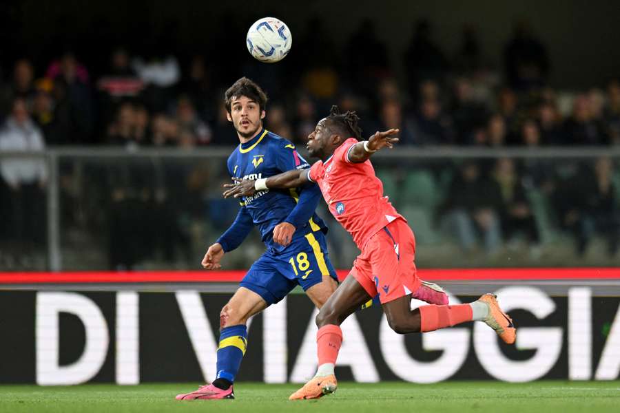 Fabien Centonze, left, of Hellas Verona makes a pass whilst under pressure from Hassane Kamara
