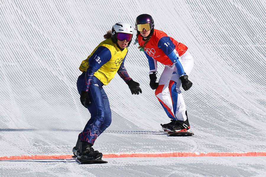 Charlotte Bankes of Britain crosses the finish line ahead of Lea Casta of France during the snowboard cross semi-finals