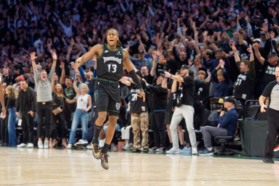 Minnesota Timberwolves guard Ayo Dosunmu celebrates with fans after making a three-point shot against the Denver Nuggets