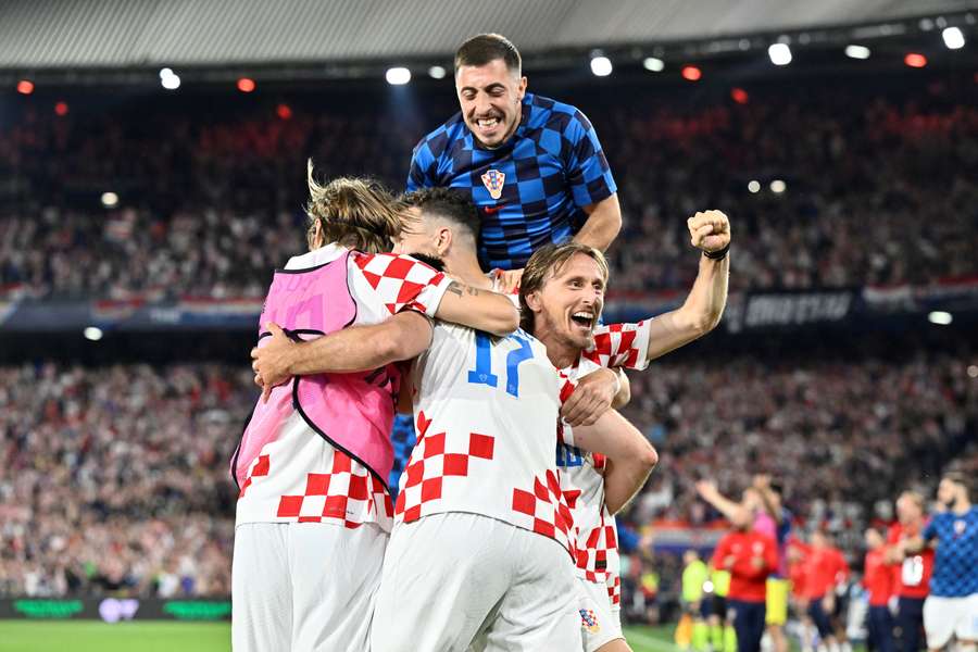 Chorwacki pomocnik Luka Modric (R) świętuje z kolegami z drużyny po zdobyciu czwartego gola podczas półfinału Ligi Narodów UEFA.