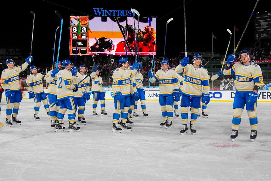 Hokejisté St. Louis Blues slaví výhru v zápase pod širým nebem.