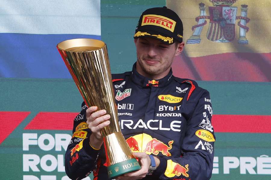 Verstappen celebrates with a trophy on the podium after winning the Brazilian Grand Prix