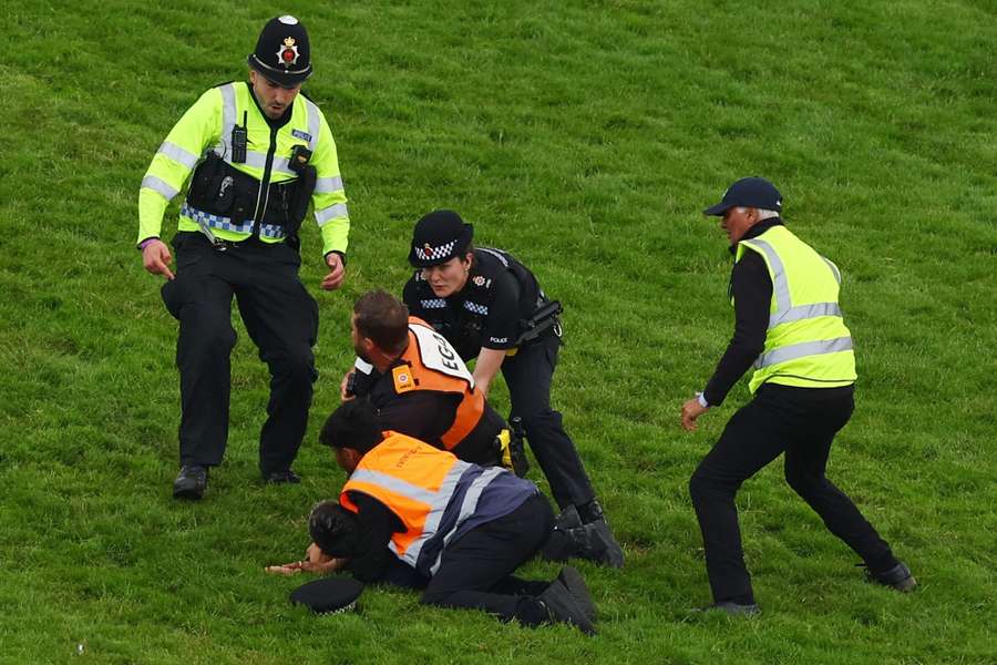An Animal Rising protester is arrested by police at the Epsom Derby