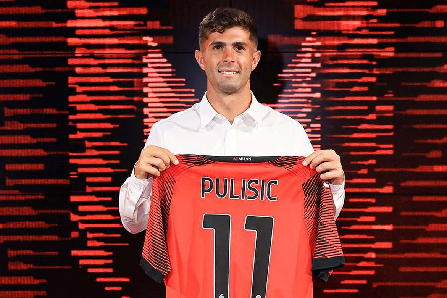 Pulisic holding his new Milan shirt