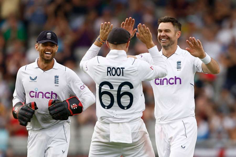 Joe Root, centre, and Ben Foakes, left, congratulate James Anderson after he takes a wicket