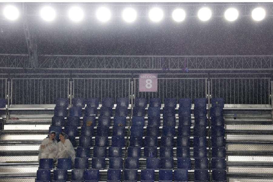 Spectators take cover as rain suspends play Spectators take cover as rain suspends play