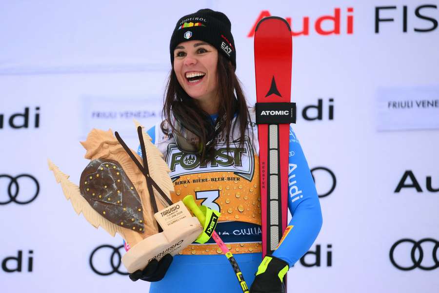Italy's Nicol Delago celebrates on the podium of the Women's Downhill event of the FIS Alpine Skiing World Cup in Tarvisio