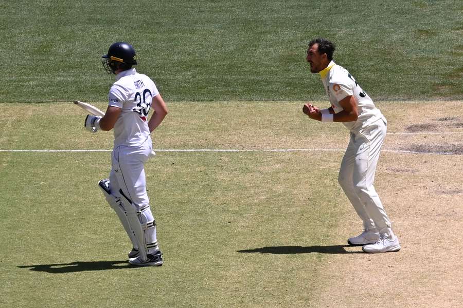 Mitchell Starc celebrates the key dismissal of Jamie Smith on Sunday afternoon. 