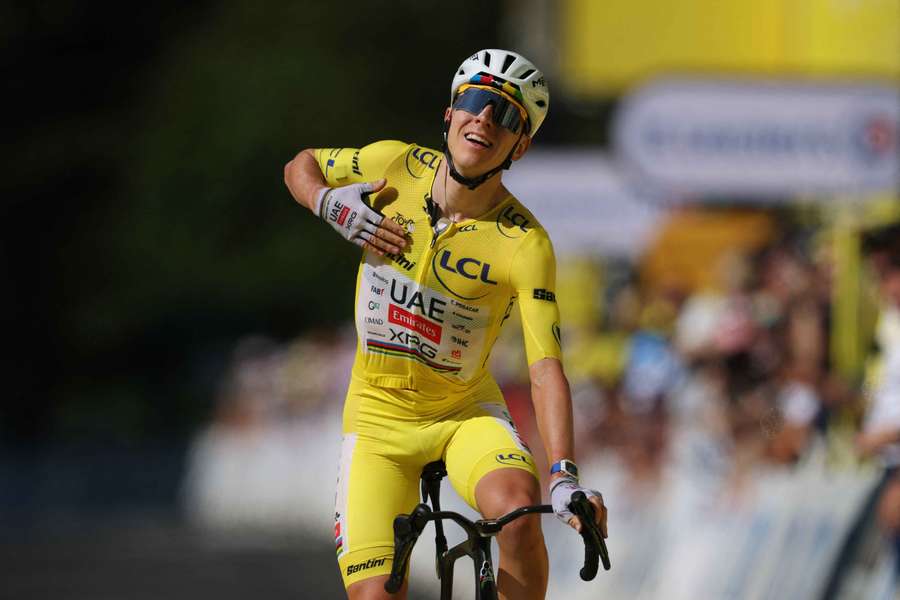 Tadej Pogacar, wearing the yellow jersey, celebrates winning stage 10