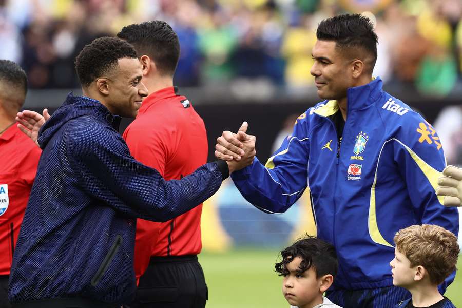 Mbappé z Francúzska sa zdraví s Casemirom z Brazílie.