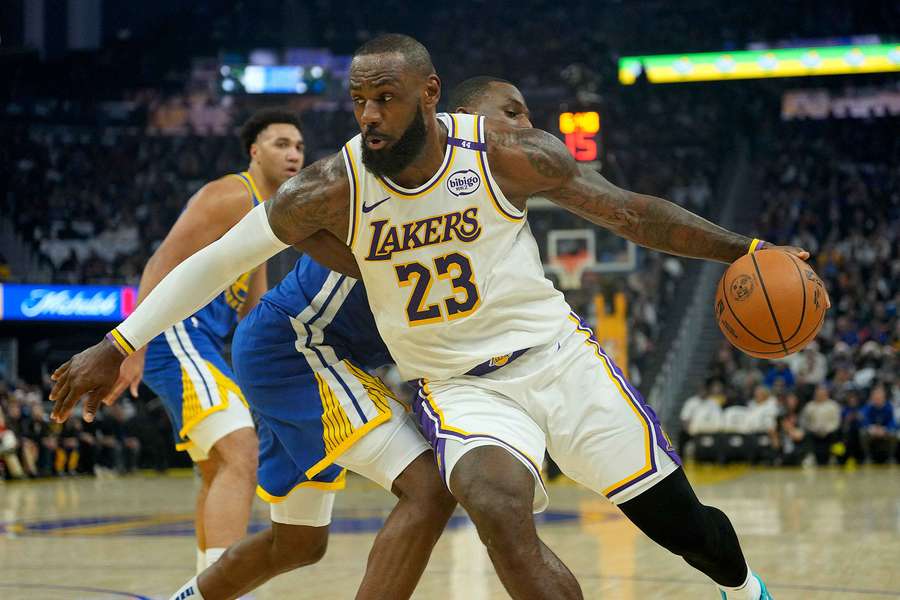 LeBron James of the Los Angeles Lakers drives to the basket on Andrew Wiggins of the Golden State Warriors
