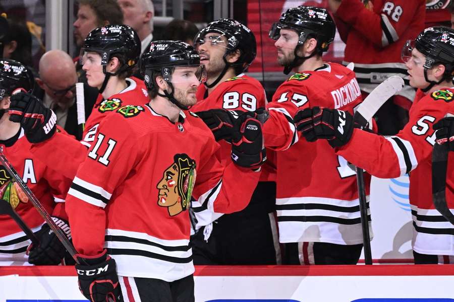 Taylor Raddysh of the Chicago Blackhawks celebrates with his teammates