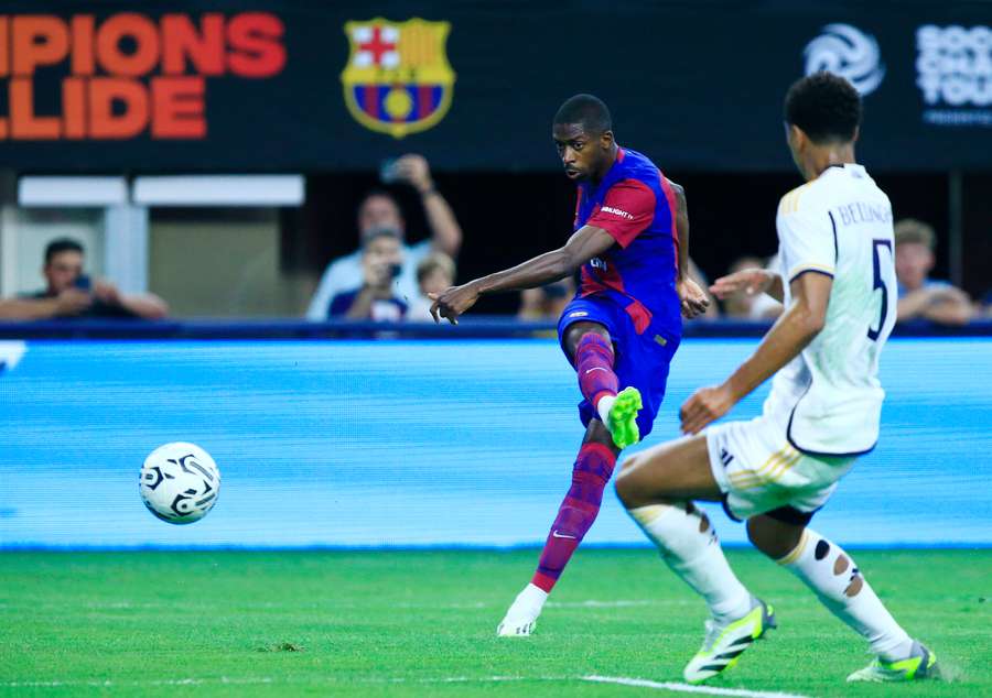 Ousmane Dembele (L) z Barcelony skóruje přes Jude Bellinghama z Realu Madrid.