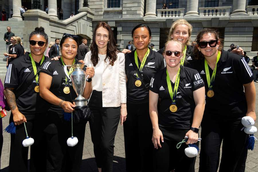 New Zealand's PM (C) poses for a photo with some of the players