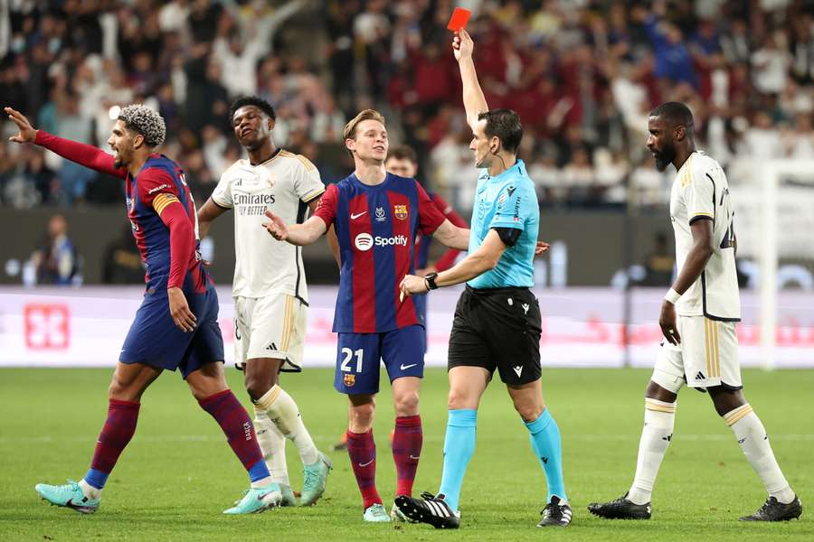 Spanish match referee Juan Martinez Munuera shows Barcelona's Uruguayan defender #04 Ronald Araujo a red card