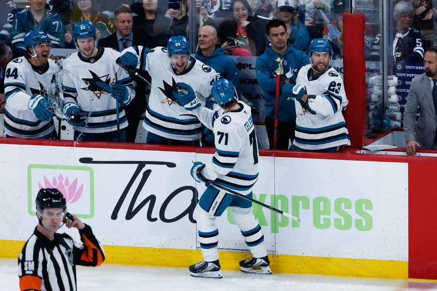 San Jose Sharks center Macklin Celebrini celebrates with his teammates after breaking his team's season scoring record.