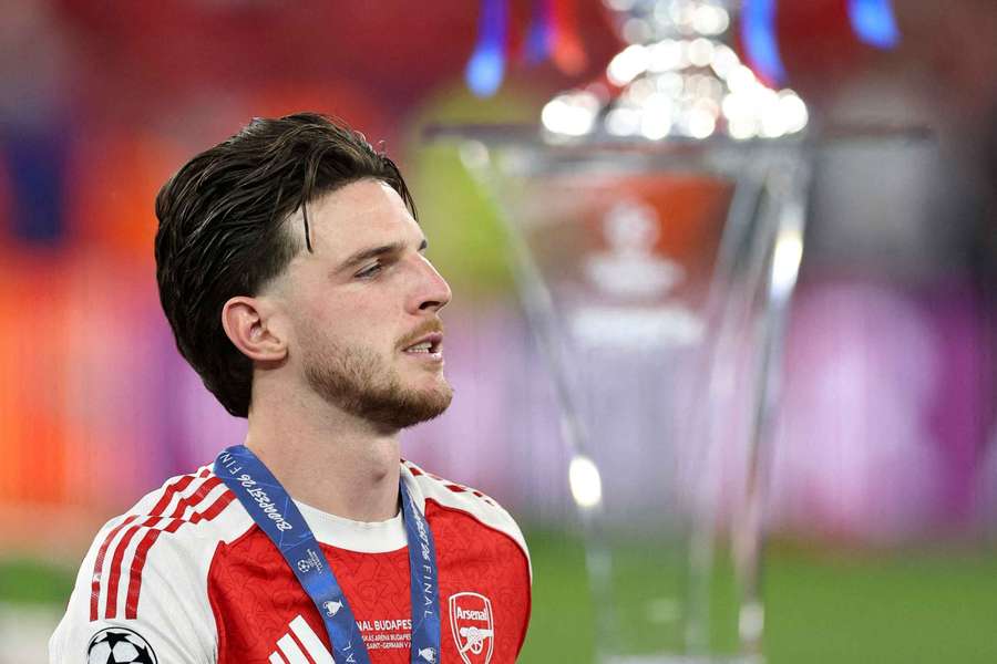 Declan Rice, cabizbajo, pasa junto al trofeo tras el partido