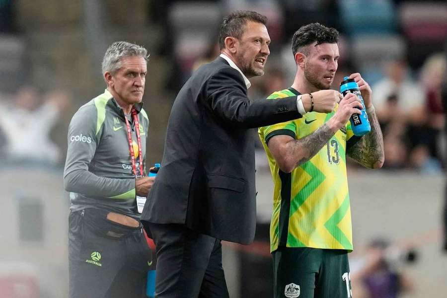 Australia's head coach Tony Popovic, center, talks with Australia's Aiden O'Neill (13) Australia's head coach Tony Popovic, center, talks with Australia's Aiden O'Neill (13)