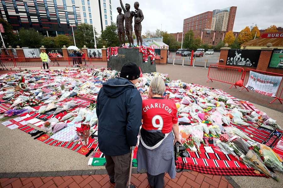 Sinds zijn overlijden ziet het er zo uit bij het standbeeld van George Best, Denis Law and Bobby Charlton voor Old Trafford