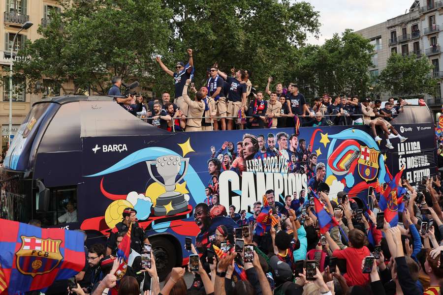 The players and staff of FC Barcelona men football team parade aboard a open-top bus followed by the women's team