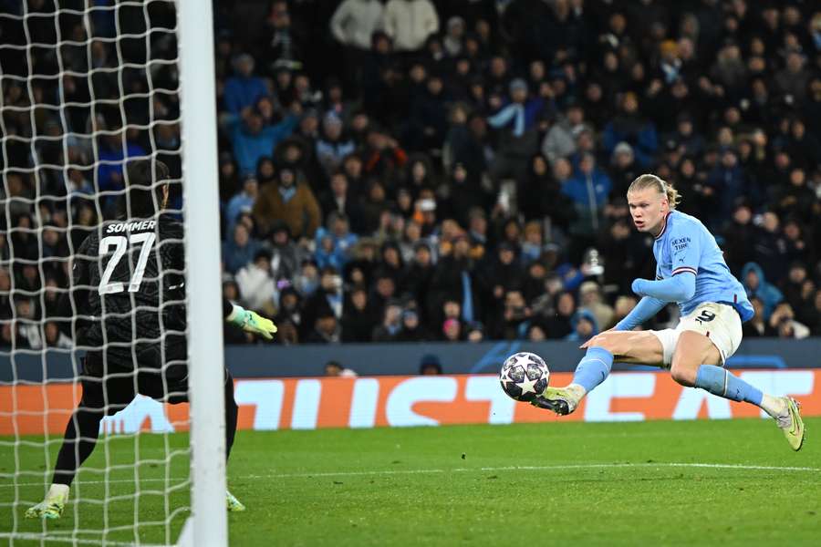 El delantero noruego del Manchester City Erling Haaland dispara para marcar su tercer gol