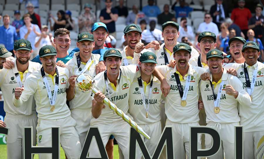 Australia's Pat Cummins (C) lifts the ICC Test Championship Mace as he celebrates with teammates after victory in the ICC World Test Championship