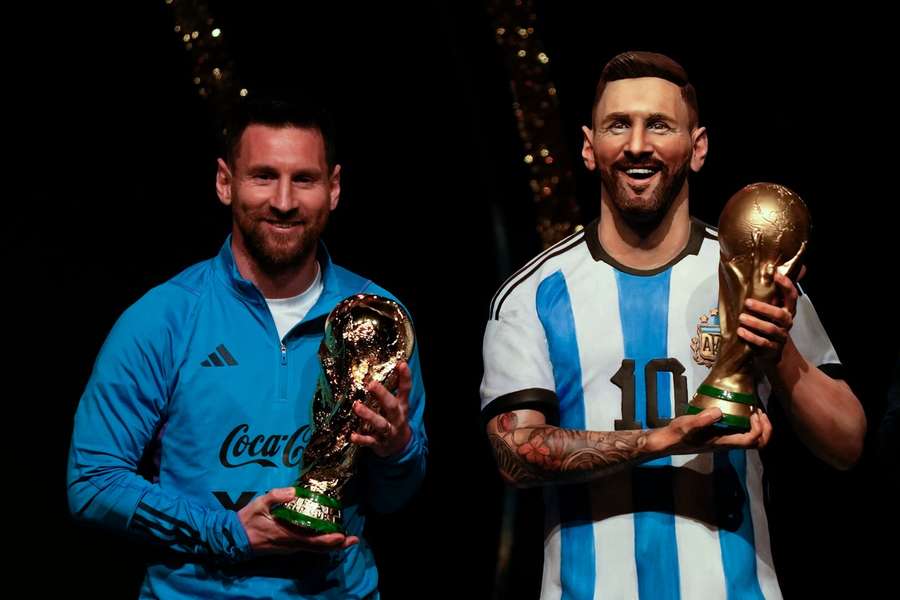 Lionel Messi naast zijn standbeeld