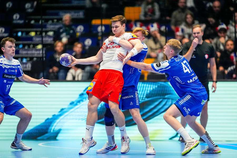 Denmark's Lukas Jorgensen is manhandled by the Faroese defense during the test match in Golden League