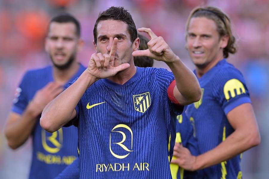 Koke (centre) celebrates his goal