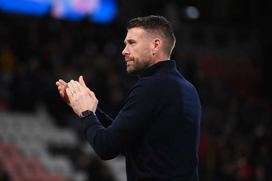 Rob Edwards, manager of Luton Town, applaud the fans after coming out of the tunnel after the match is suspended