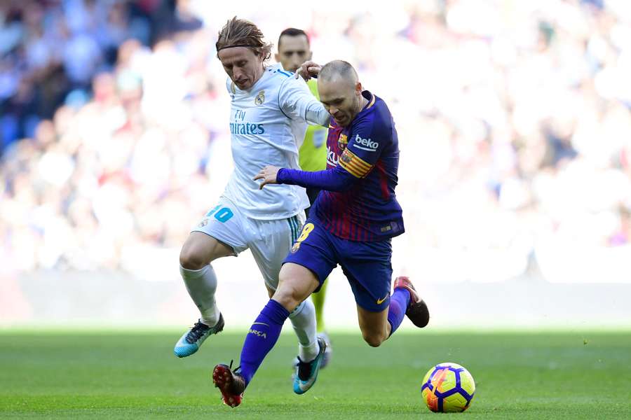 Iniesta se luptă pentru minge cu Modric în timpul unui Clásico.