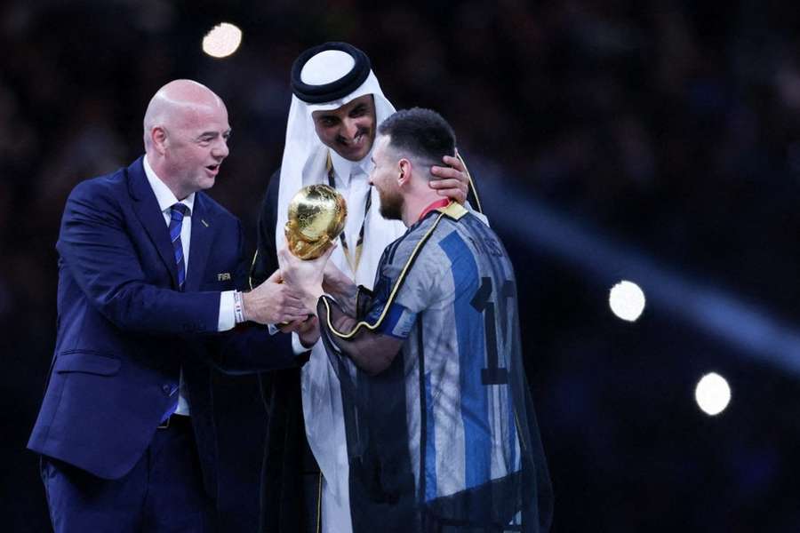 Infantino remettant la Coupe du monde 2022 à Lionel Messi au Qatar.
