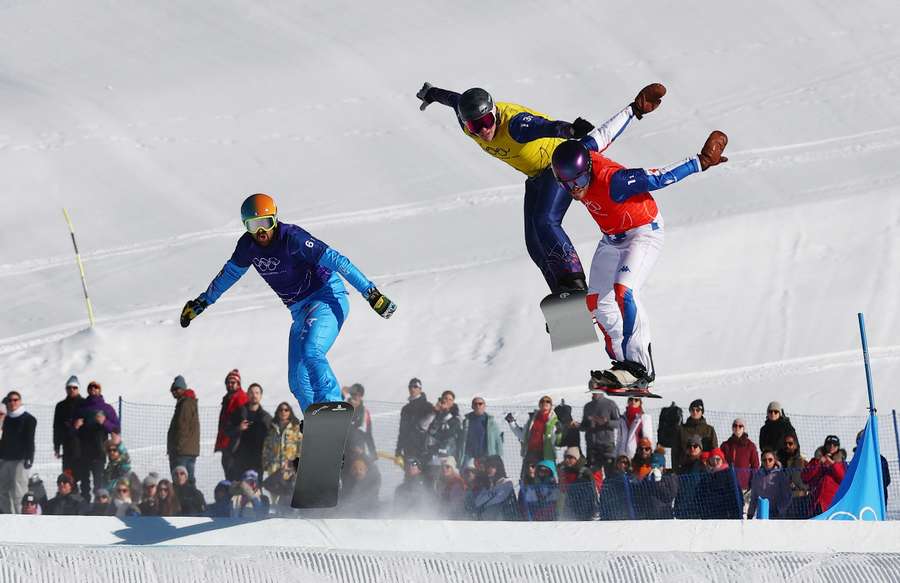 Lorenzo Sommariva of Italy, Huw Nightingale of Britain and Loan Bozzolo of France in action during the mixed snowboard cross