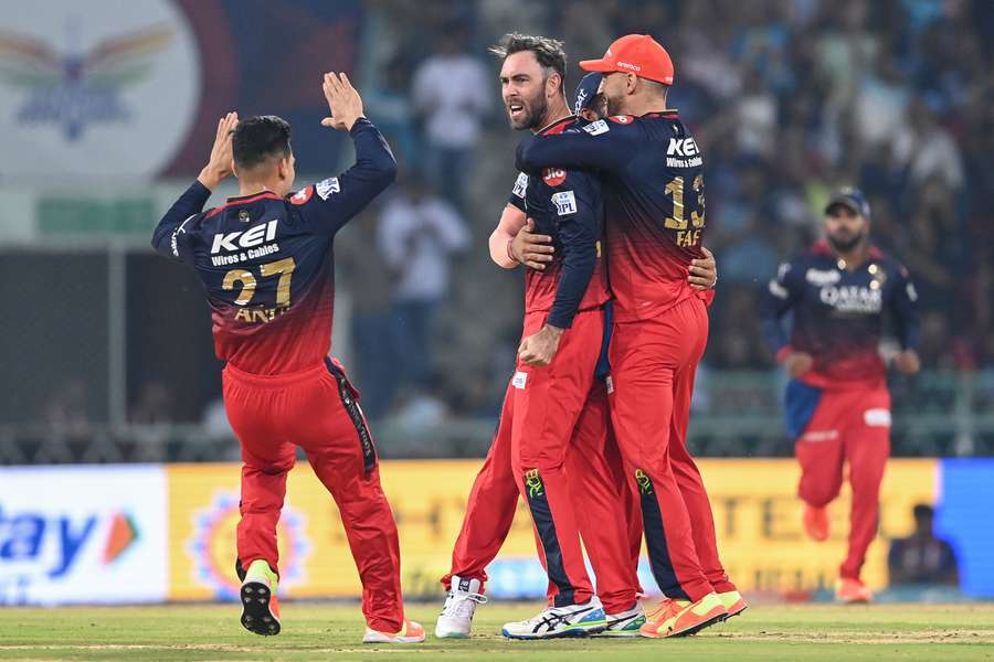Royal Challengers Bangalore's Glenn Maxwell (C) celebrates with teammates after taking the wicket of Lucknow Super Giants' Krunal Pandya