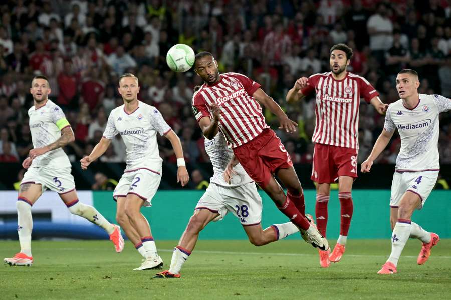 Olympiacos striker Ayoub El Kaabi heads the ball next to Fiorentina defender Lucas Martinez Quarta