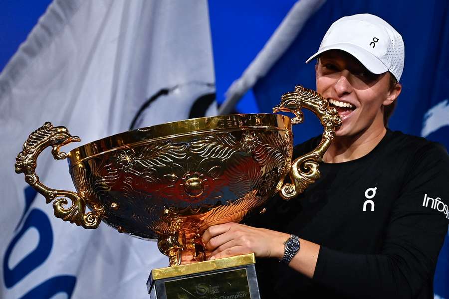 Poland's Iga Swiatek holds the winning trophy after defeating Russia's Liudmila Samsonova