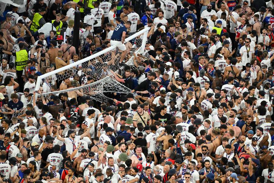 Paris Saint-Germain fans invade the pitch as one fan climbs on the goal after winning the Champions League Paris Saint-Germain fans invade the pitch as one fan climbs on the goal after winning the Champions League