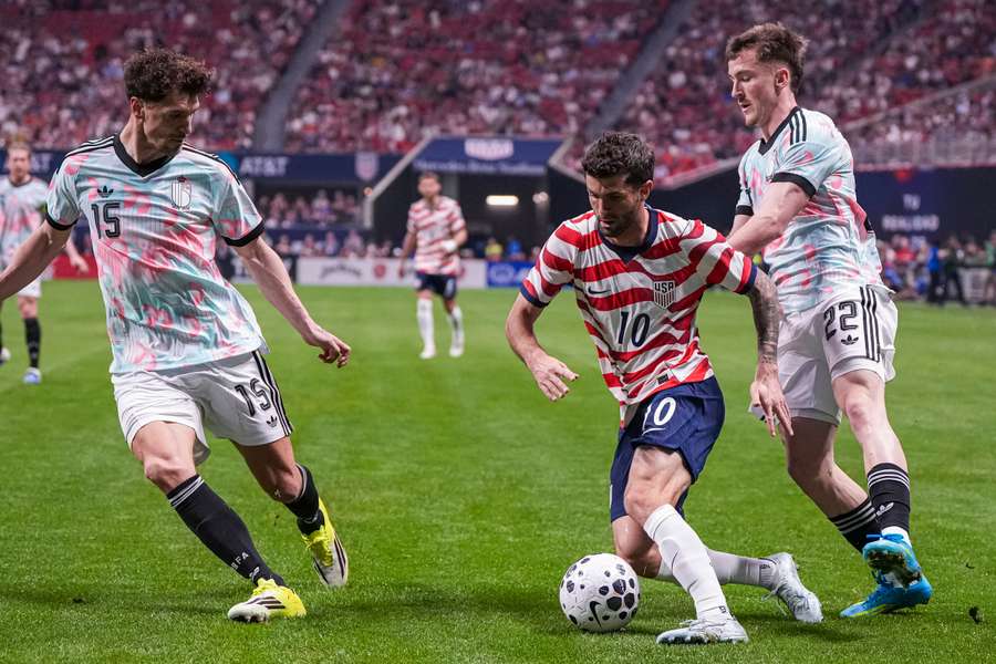 USA’s Christian Pulisic (centre) controls the ball