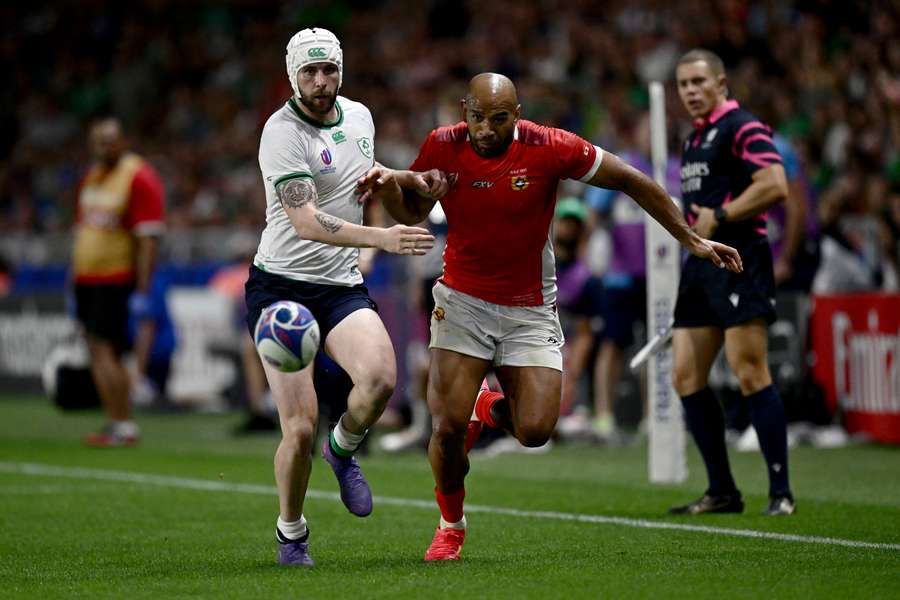 Ireland wing Mack Hansen (L) and Tonga wing Afusipa Taumoepeau run after the ball