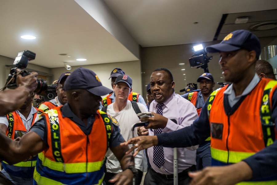 Steve Smith receives a police escort through Johannesburg's OR Tambo airport in the immediate fallout of the sandpaper scandal. Steve Smith receives a police escort through Johannesburg's OR Tambo airport in the immediate fallout of the sandpaper scandal.