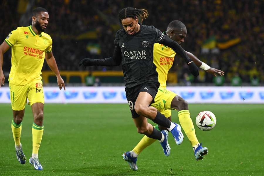 PSG's Bradley Barcola (L) fights for the ball with Nantes' Moussa Sissoko