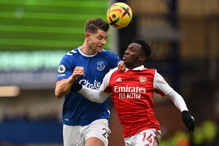 Everton's James Tarkowski (L) heads the ball with Arsenal's Eddie Nketiah