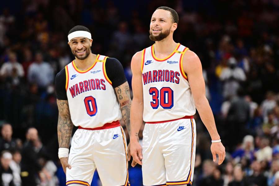 Gary Payton II (left) and Stephen Curry (right) reacting to the halfcourt shot buzzer before halftime against the Magic. (2025)