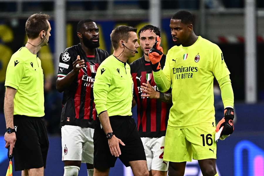 AC Milan goalkeeper Mike Maignan talks to the referee Clement Turpin