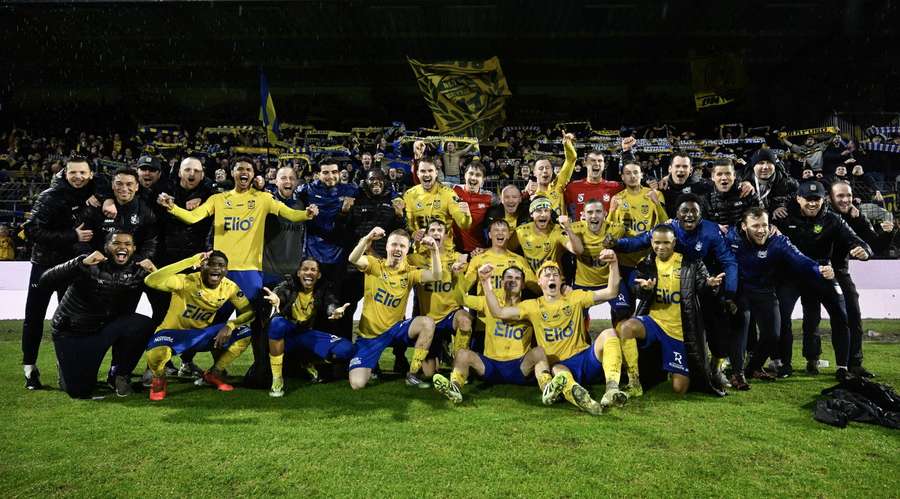 SK Beveren players celebrate clinching promotion with the travelling fans