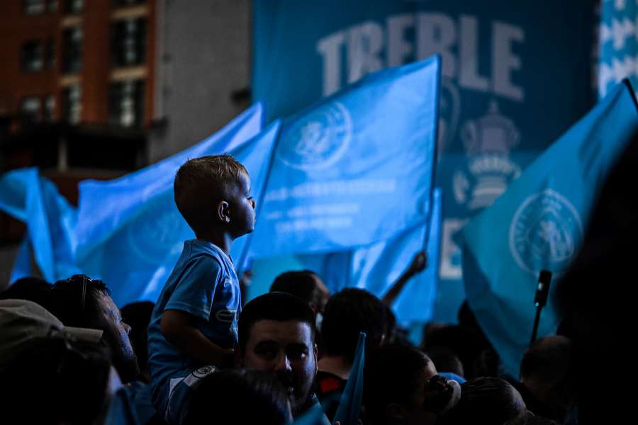 Man City supporters wait for the arrival of the players