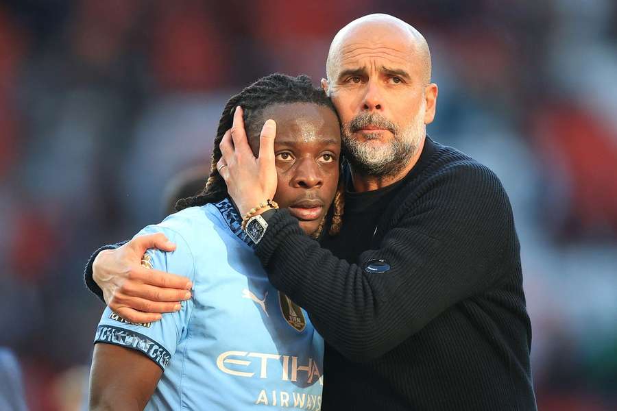 Doku abraçado pelo treinador Pep Guardiola
