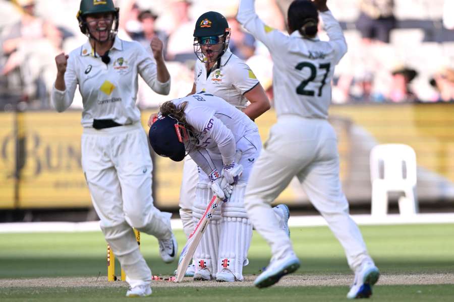 England's Tammy Beaumont (C) reacts after being bowled by Australia's Alana King