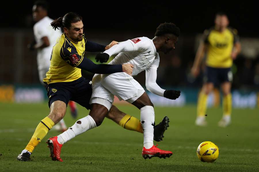 Ciaron Brown (à esquerda) viu o único cartão amarelo do jogo entre Oxford United e Arsenal